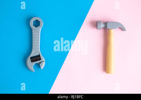 Flat lay of hammer and adjustable wrench toy tools against colorful pastel background minimal creative concept. Stock Photo