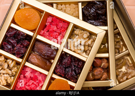 Mix of dried and sun-dried fruits, dried fruits in a wooden box on a white wooden background. dried fruits Stock Photo