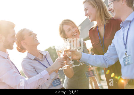 Smiling businessman colleagues toasting wineglasses during success party at terrace Stock Photo