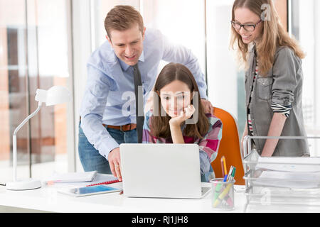 Creative business colleagues using laptop in office Stock Photo
