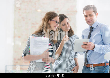 Creative businessman using digital tablet with colleagues in office Stock Photo