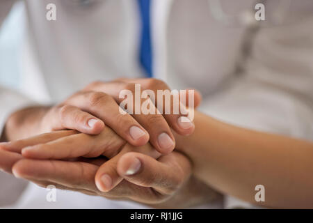 Doctor examining the hands of a young patient. Stock Photo