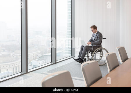 Disabled businessman using laptop in boardroom at modern office Stock Photo