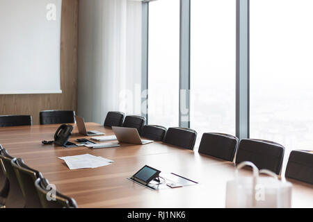 Documents with laptop and telephone on conference table in boardroom at modern office Stock Photo