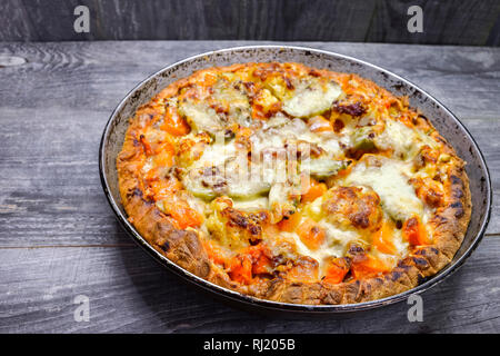 Pie with vegetables and cheese in the pan on a vintage grey wood rustic background Stock Photo