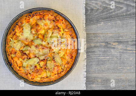 Vegetable and cheese pie in vintage pan on white linen napkin on wooden rustic background Stock Photo