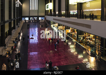 LONDON, UK - January 27, 2019: People walking or standing on the floor in the Turbine Hall of the Tate Modern Art Gallery in London on a Sunday evenin Stock Photo