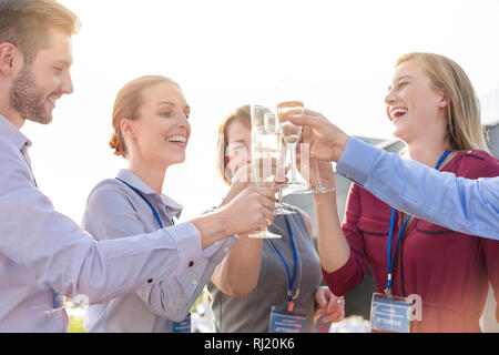 Smiling business colleagues toasting wineglasses during rooftop success party Stock Photo