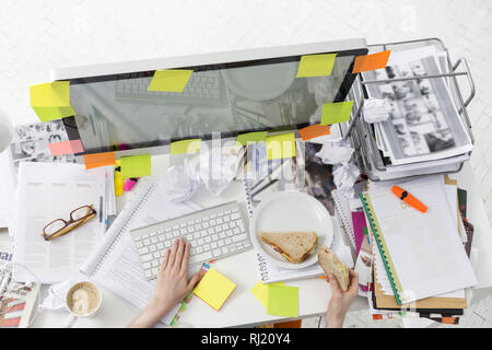 Cropped image of businessman having breakfast while working on computer Stock Photo