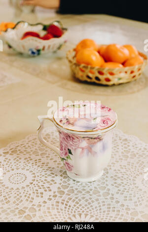 Porcelain cup and oranges on table. Stock Photo