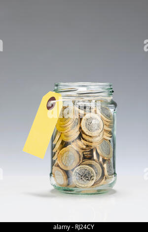 Glass Savings Jar with One Pound Coins Stock Photo