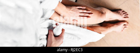 The girl in the bathroom puts anti-cellulite cream, serum on the legs and body. Body care concept. Top View. Banner