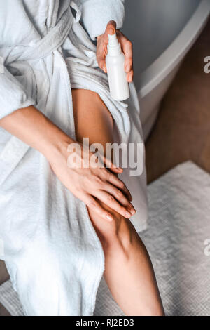 Body care. A young woman in the bathroom applies natural cream to her legs. Against varicose veins and leg edema Stock Photo
