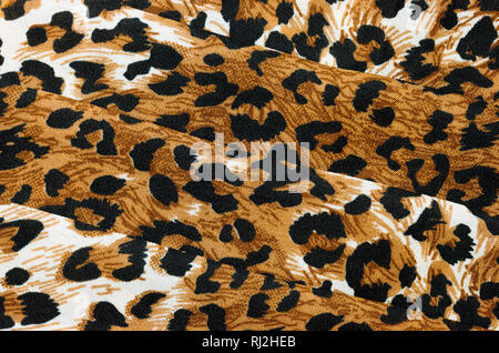 An abstract background of close up folded leopard animal print fabric Stock Photo