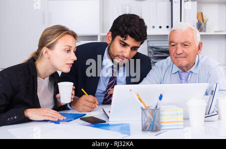 Managers are writing financial reports in the office. Stock Photo