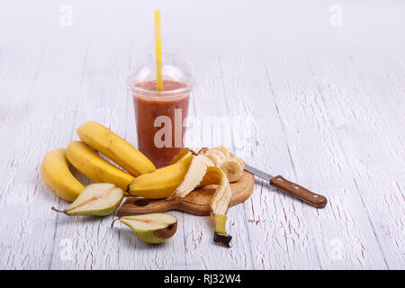 red detox coctail with bananas on chopping board lies on white table Stock Photo