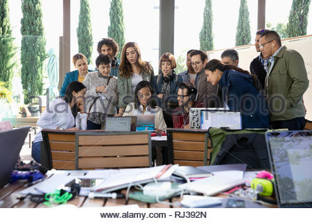 Millennial hackers working at laptop, meeting