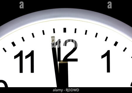 Close up of a clock showing one minute to 12, midnight. Stock Photo