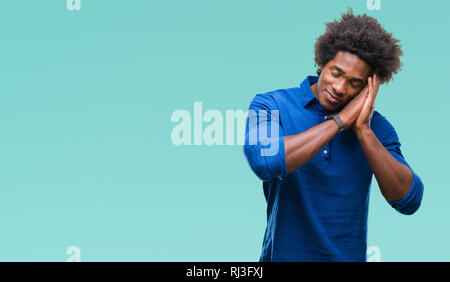 Afro american man over isolated background sleeping tired dreaming and posing with hands together while smiling with closed eyes. Stock Photo