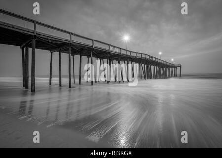 Waves in the Atlantic Ocean and the fishing pier at twilight, in Ocean City, Maryland. Stock Photo