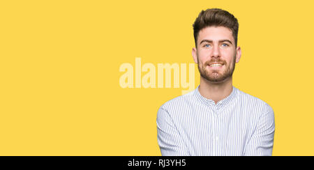 Young handsome man Smiling with hands palms together receiving or giving gesture. Hold and protection Stock Photo
