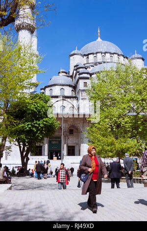 Istanbul, Turkey : People walk past the New Mosque (Yeni Camii) built between 1660 and 1665, an Ottoman imperial mosque in the Eminönü quarter, on the Stock Photo