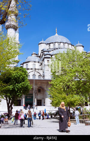 Istanbul, Turkey : People walk past the New Mosque (Yeni Camii) built between 1660 and 1665, an Ottoman imperial mosque in the Eminönü quarter, on the Stock Photo