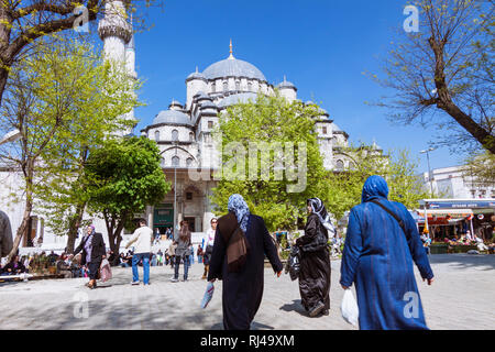 Istanbul, Turkey : People walk past the New Mosque (Yeni Camii) built between 1660 and 1665, an Ottoman imperial mosque in the Eminönü quarter, on the Stock Photo