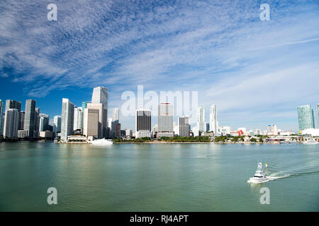 Aerial view of Miami skyscrapers with blue cloudy sky, boat sailing next to Miami downtown Stock Photo