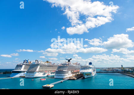 Nassau, Bahamas-February 18, 2016: Large luxury cruise ships of Carnival, Norwegian and Royal Caribbean cruise lines docked in port of Nassau, Bahamas on sea water and cloudy sky background Stock Photo