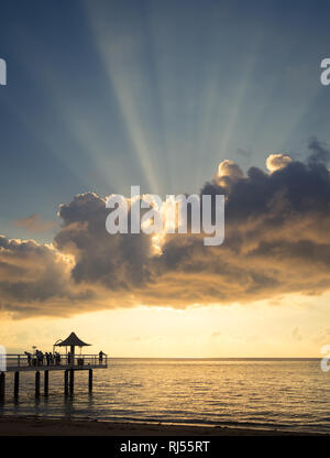A view of a gorgeous sunset over Fusaki Angel Pier and Fusaki Beach in Ishigaki, Japan. Note the anticrepuscular rays (crespuscular rays, God rays). Stock Photo