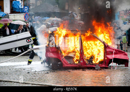 Car fire and flames at show in Kazimierz Dolny, accident improvisation, Fire man in action at show in Poland, Red vehicle appliances detail, Stock Photo