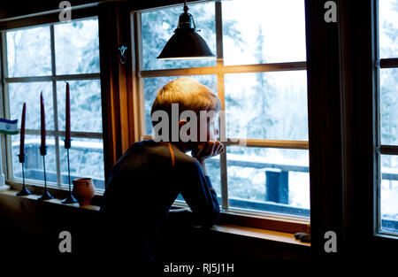 Boy looking out of a window Stock Photo
