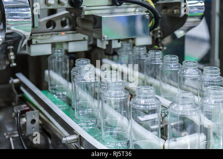 Clear Glass bottles transfer on Automated conveyor systems industrial automation for package Stock Photo