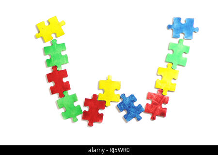 Colourful jigsaw puzzle and alphabet tiles with AUTISM word. Autism concept Stock Photo