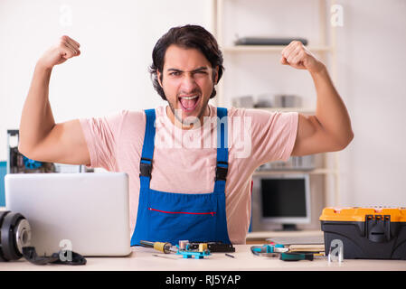 Young male contractor repairing computer Stock Photo