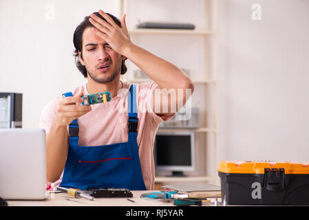 Young male contractor repairing computer Stock Photo