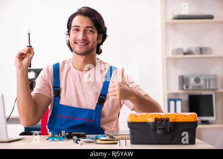 Young male contractor repairing computer Stock Photo