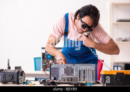Young male contractor repairing computer Stock Photo