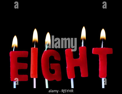 Eight spellt out in red birthday candles against a black background Stock Photo