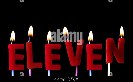 Eleven spellt out in red birthday candles against a black background Stock Photo