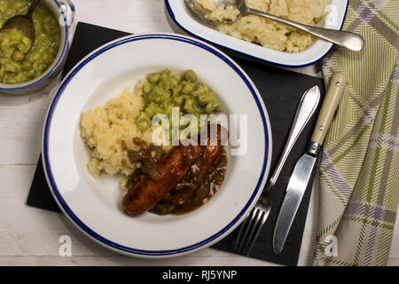 very typical irish dish, mashed potato, onion gravey, grilled sausages and mushy peas Stock Photo