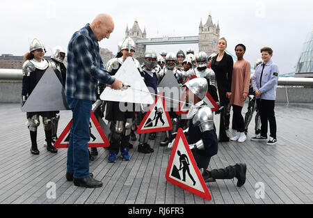 Rebecca Ferguso, Rhianna Dorriss, and Louis Ashbourne Serkis look on as Sir Patrick Stewart knights pupils from Snowsfields Primary school and Tower Bridge Primary school at a photo call for cast-members from The Kid Who Would Be King against the backdrop of Tower Bridge and City Hall, at 2 More London Riverside, London. Stock Photo