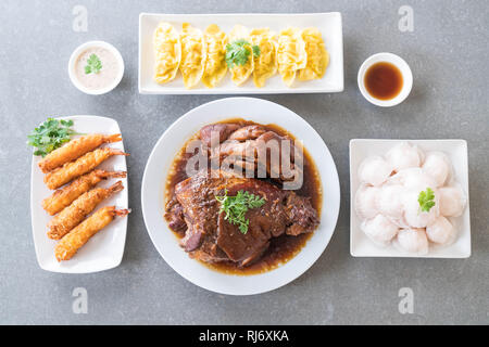 Stewed pork leg in gravy soup, Steamed shrimp dumplings dim sum and Batter-fried prawns on dining table Stock Photo