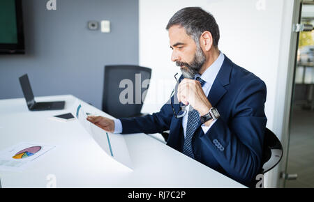 Confident senior businessman leader working in office Stock Photo