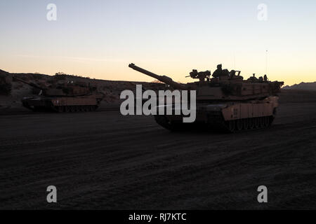 U.S. Army M1A2 Abrams tanks assigned to 3rd Armored Brigade Combat Team, 1st Cavalry Division, Fort Hood, Texas, prepares to maneuver forward and engage enemy elements while conducting live-fire exercises during Decisive Action Rotation 19-03 at the National Training Center (NTC), Fort Irwin, Calif., Jan. 23, 2019.  Decisive Action Rotations at NTC ensures Army Brigade Combat Teams remain versatile, responsive, and consistently available for current and future contingencies. (U.S. Army photo by Pvt. Brooke Davis, Operations Group, National Training Center) Stock Photo