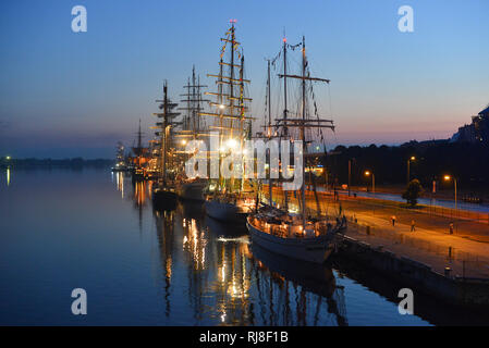 The world largest tall ships berthed in port of Riga, Latvia. Daugava river. Summer night. Dawn. Stock Photo