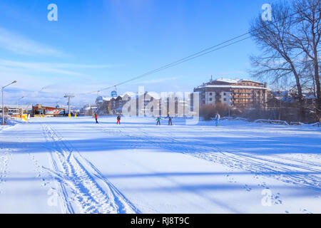 Bansko, Bulgaria - January 22, 2018: Winter ski resort Bansko with ski slope, lift cabins, people and mountains view Stock Photo