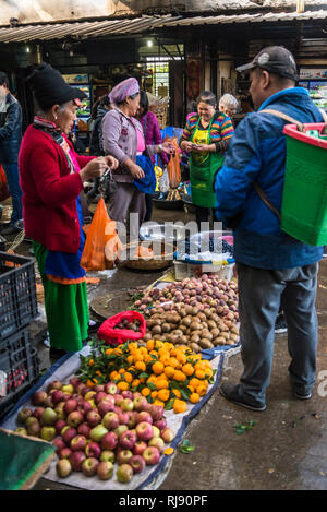 Food market, Bai woman market seller dressed in ethnic costume, Dali Old Town, Yunnan province, China Stock Photo