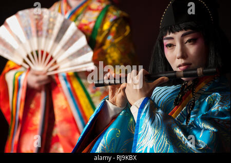 Florence, Italy - November 18, 2017: Beautiful japanese young woman in traditional kimono, plays a wooden flute during a show at "Japanese Festival 20 Stock Photo